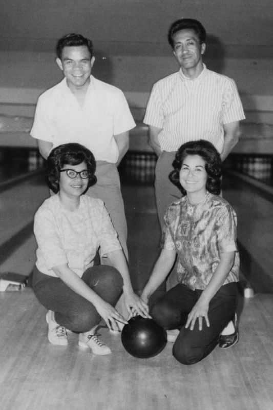 Photo of Filipino teenagers posing in a bowling alley with bowling bowls in the 50s.