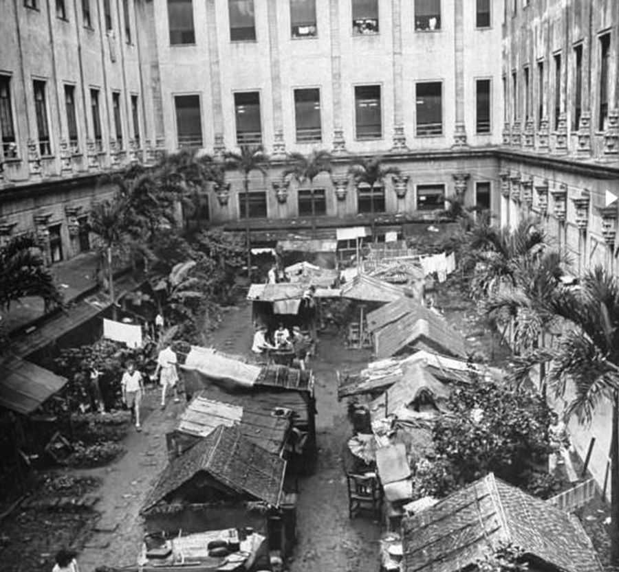 Overhead photo of shacks built in the outdoor plaza between the wings of a larger building